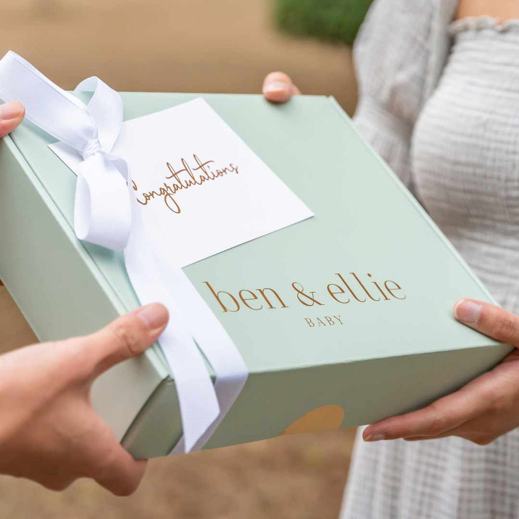 Women Exchanging Baby Shower Gift In A Sage Box With White Ribbon And Congratulations Card | Ben & Ellie Baby
